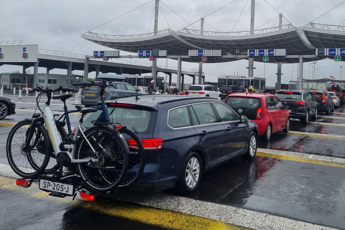 Auto con portabici e biciclette in coda al check-in del terminal